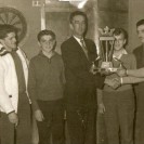 Monsieur André Pichette, propriétaire de l'hôtel LaSalle remet le trophée à l'équipe gagnante lors d'un tournoi de dards, monsieur Vachon et ses jeunes frères